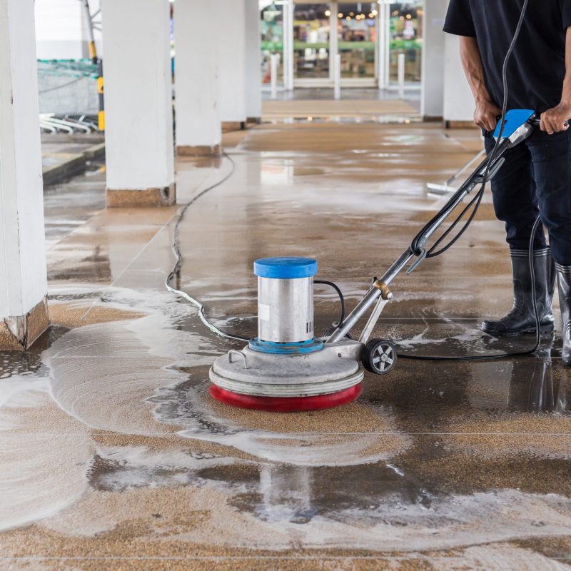 Asian worker cleaning sand wash exterior walkway