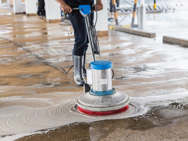 Asian worker cleaning sand wash exterior walkway