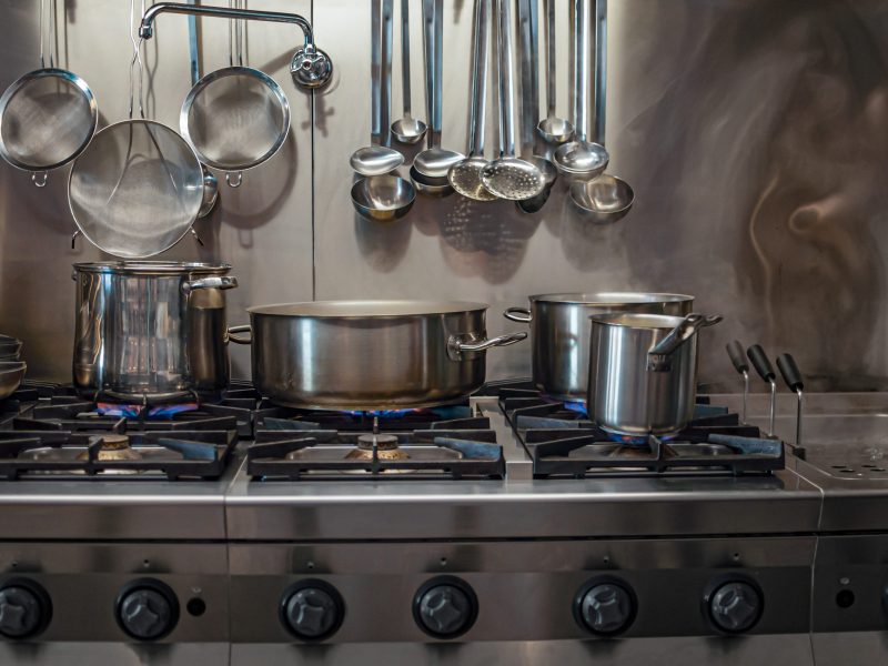 Professional gas stove with pans in the kitchen in a restaurant